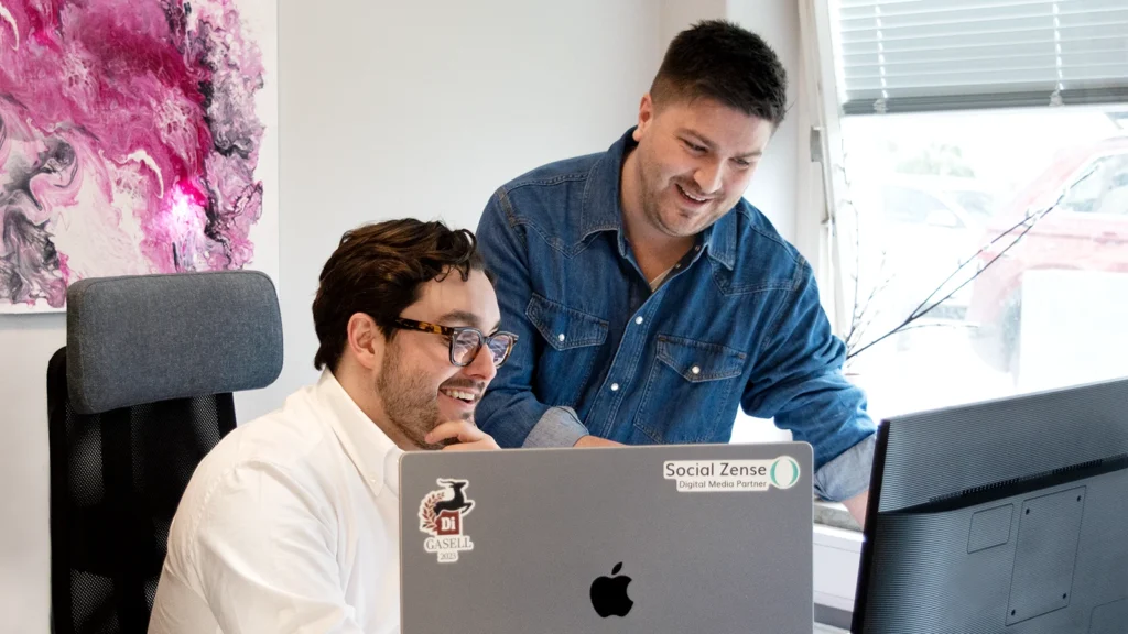 David och Jonathan framför en dator med klistermärken.