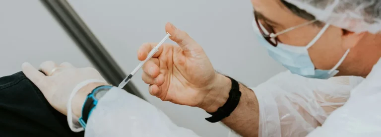 En läkare distribuerar vaccin till patient på klinik.